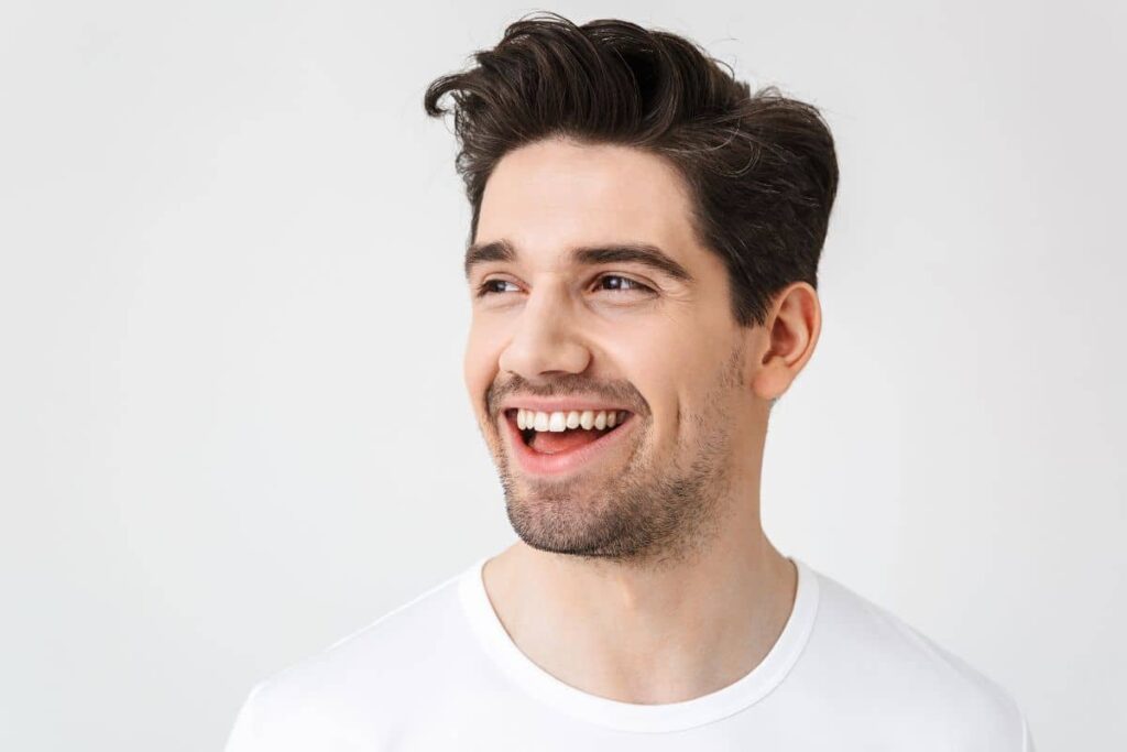 Cheerful man with clear skin and full hair reflecting subtle, lasting effects of Ariessence PDGF+ therapy.
