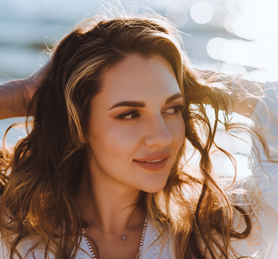 Woman with glowing skin smiling outdoors after PDGF-BB treatment for collagen boost and skin rejuvenation