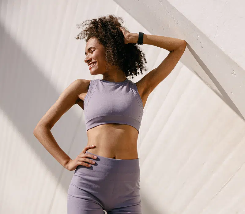 Active woman in workout attire beside text explaining ideal candidates for Alloclae non-surgical contour treatment