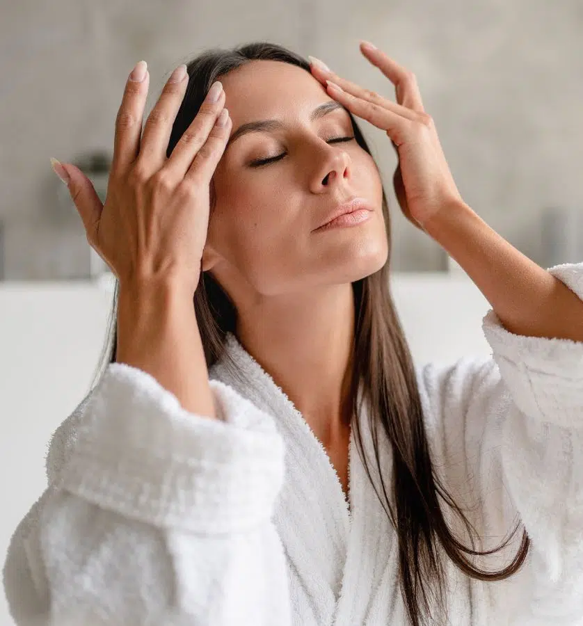 Woman touching skin after BioRePeel treatment, showing healthy glow and minimal recovery during aftercare.