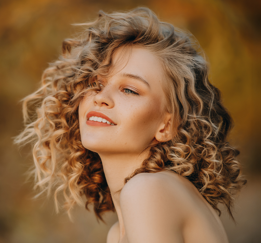 Smiling woman with healthy-looking skin, representing SKINVIVE by JUVÉDERM treatment for neck lines in Newburgh, NY.